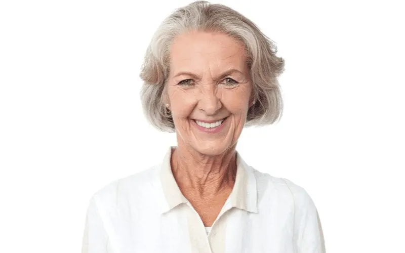 Lady over 60 with a short haircut in a white eggshell shirt