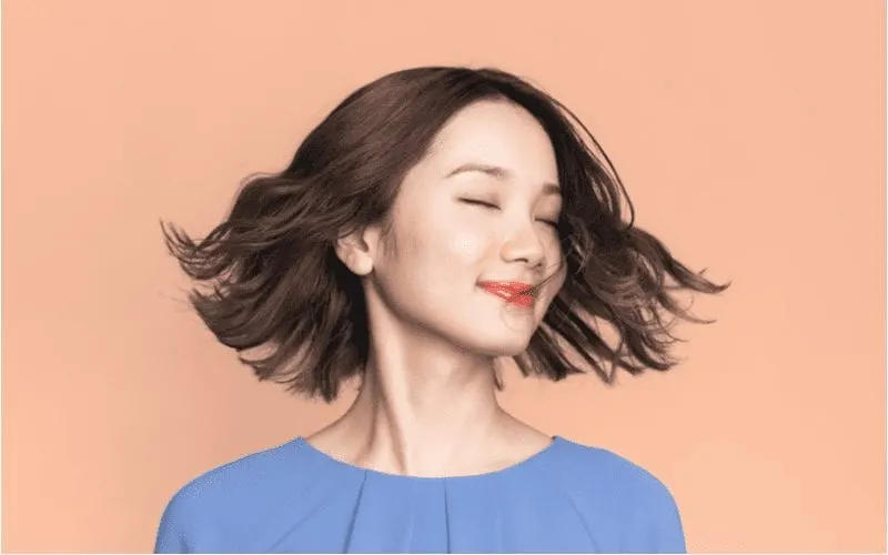 To answer what is a lob haircut, an asian woman spinning her hair