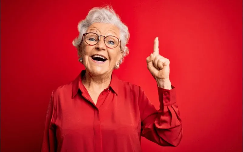 Woman with a Curly Casual Crop holds a finger up for a piece on best short haircuts for older woman
