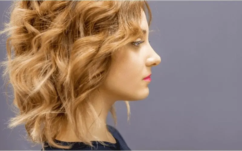 Woman with a red long wavy lob haircut in a side profile
