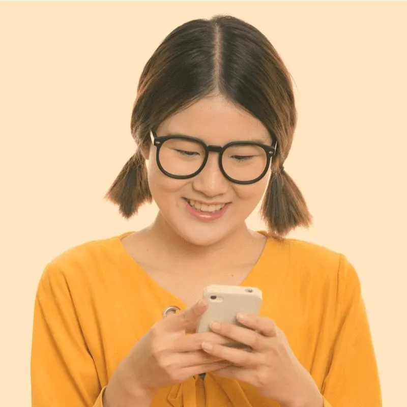 Midi Pigtails with an Asian woman smiling looking at a phone