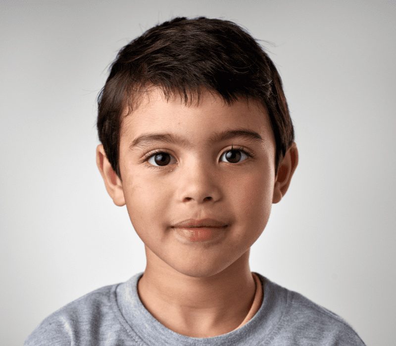 Short Taper With Fringe on a boy with a gray shirt looking directly at the camera