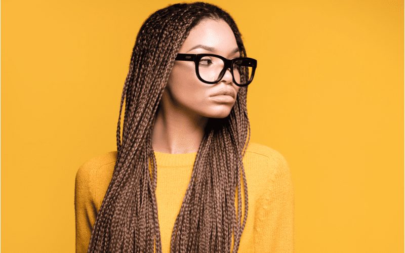 Woman with long lemonade box microbraids wears glasses for a piece on types of braids