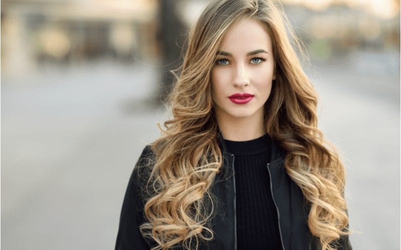 Balayage and Graduated Layers on a woman in a black turtleneck and a black jacket