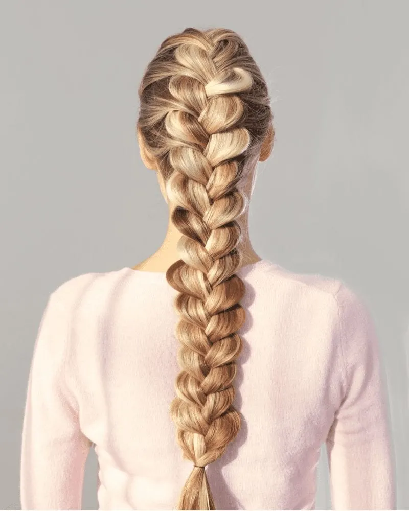 Woman with a long pulled-out fishtail braid wears a fuzzy white sweater
