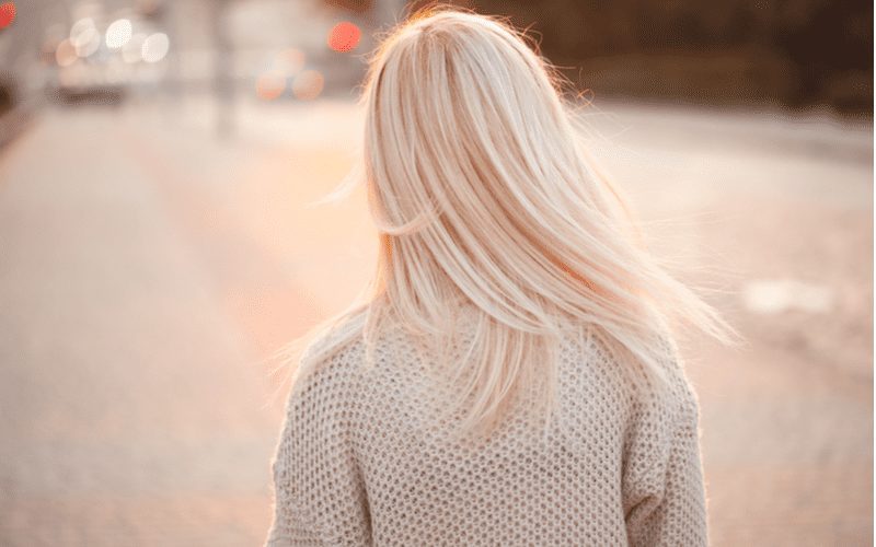 Wispy Layered Ends on a woman walking in a street with bright blonde hair