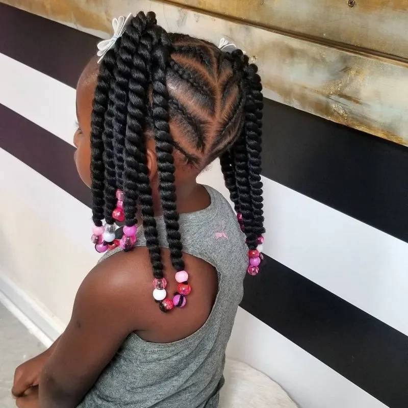 Toddler wearing a braided hairstyle in a black and white room with shiplap on the wall