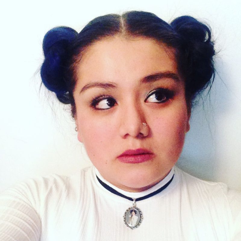 Traditional Leia space buns on a girl in a star wars costume and Leia necklace