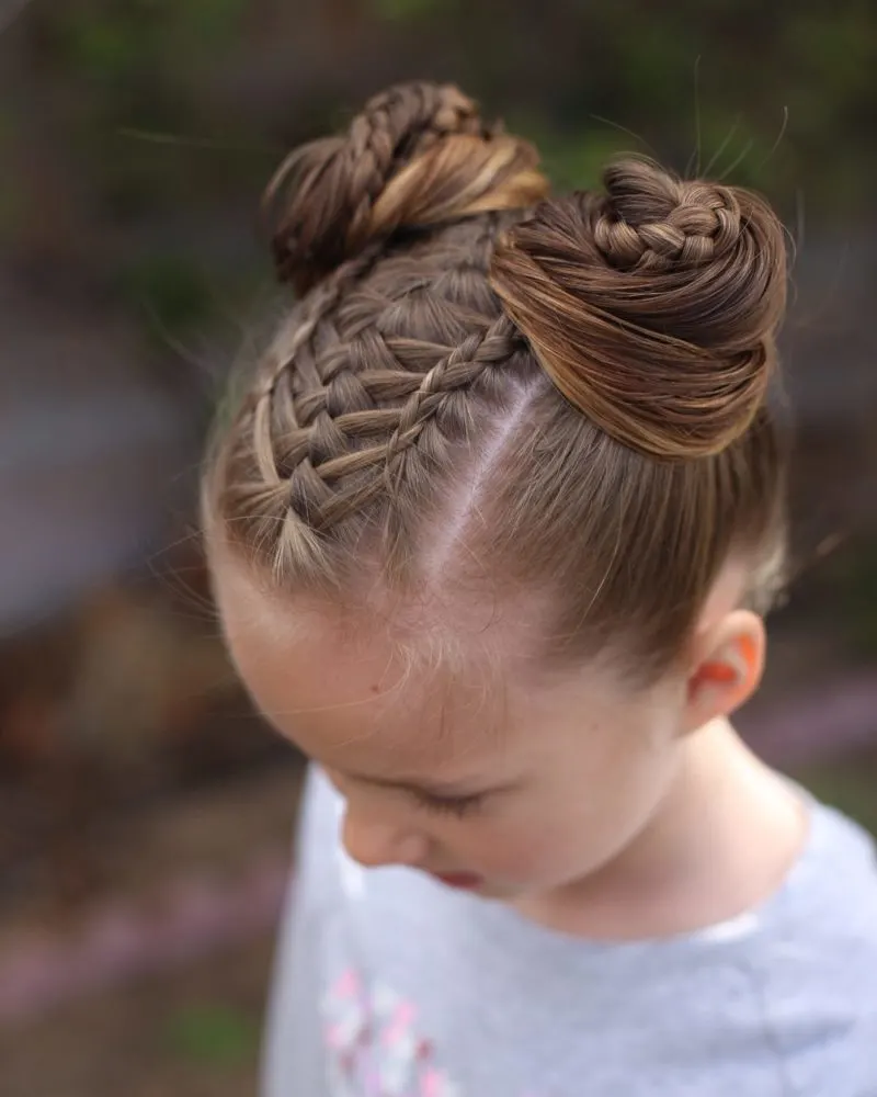 Double braid buns as an example of toddlers braided hairstyles on a gal standing outside