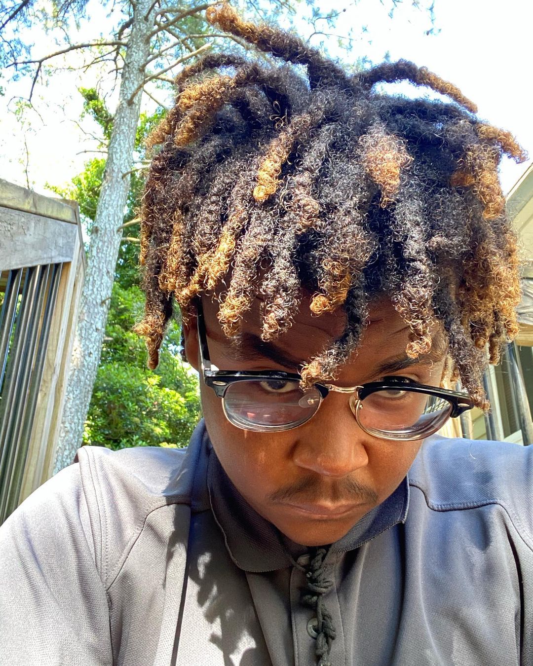 Juice wrld hair, aka dyed freeform dreads, on a guy who looks like the late rapper wearing glasses