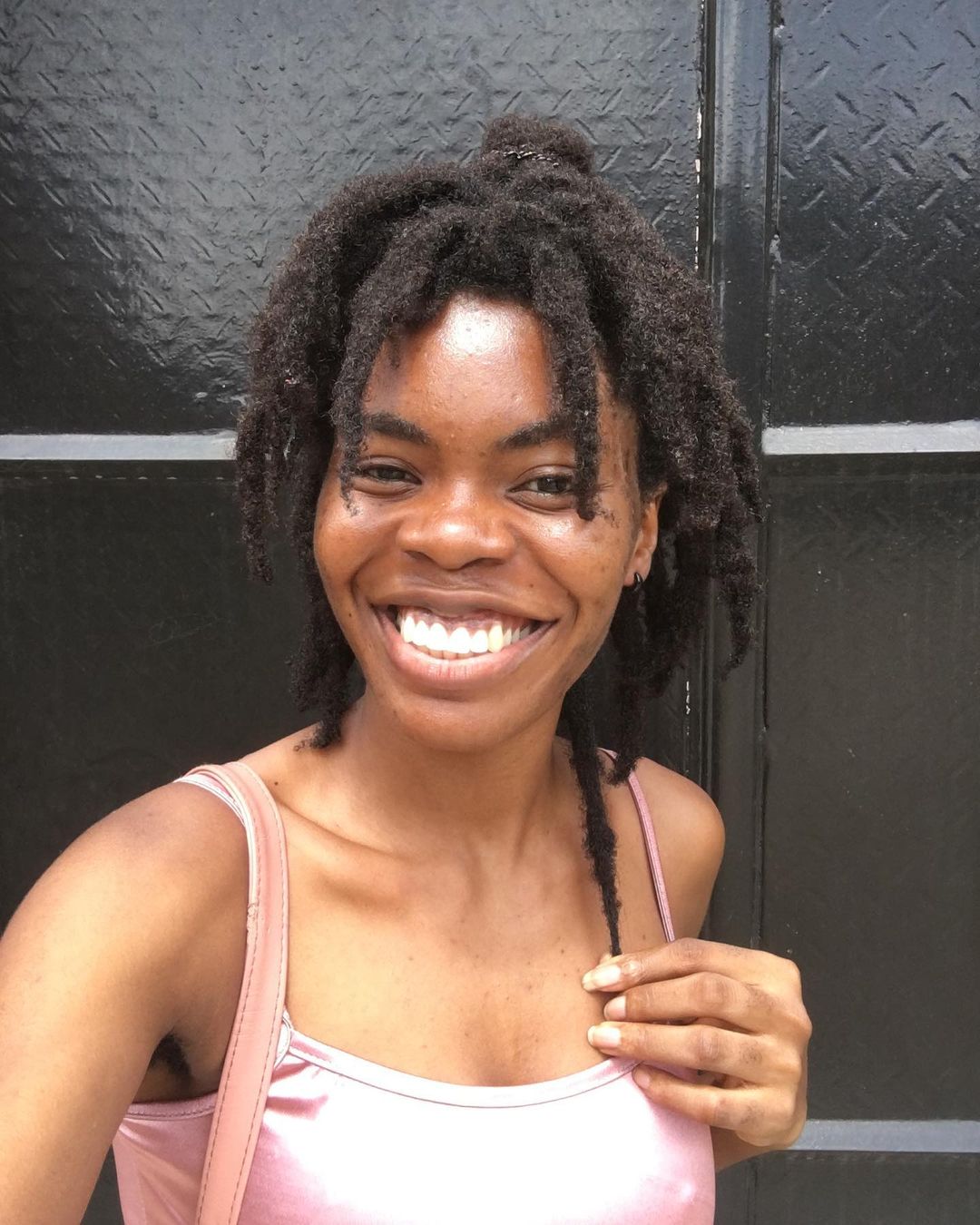 Pretty smiling gal with freeform dreads after 1 year