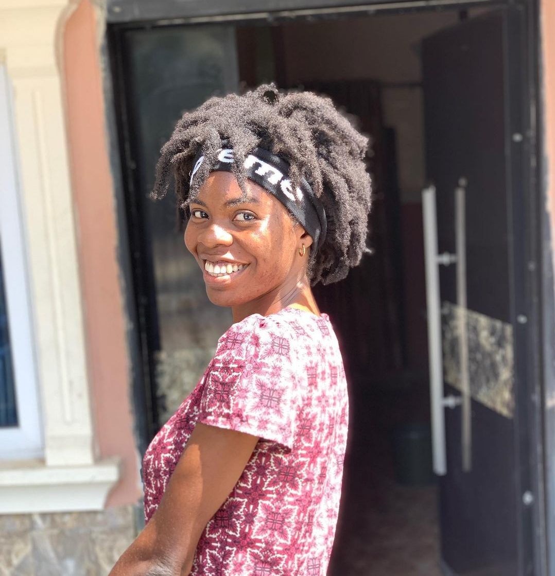 Young lady with freeform locs after 8 months old stands outside