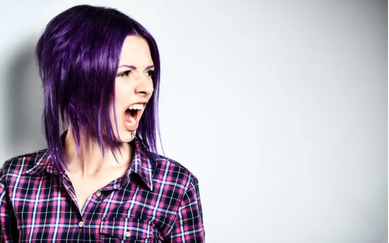 Purple hair inverted bob emo hairstyle on a gal in a purple plaid shirt