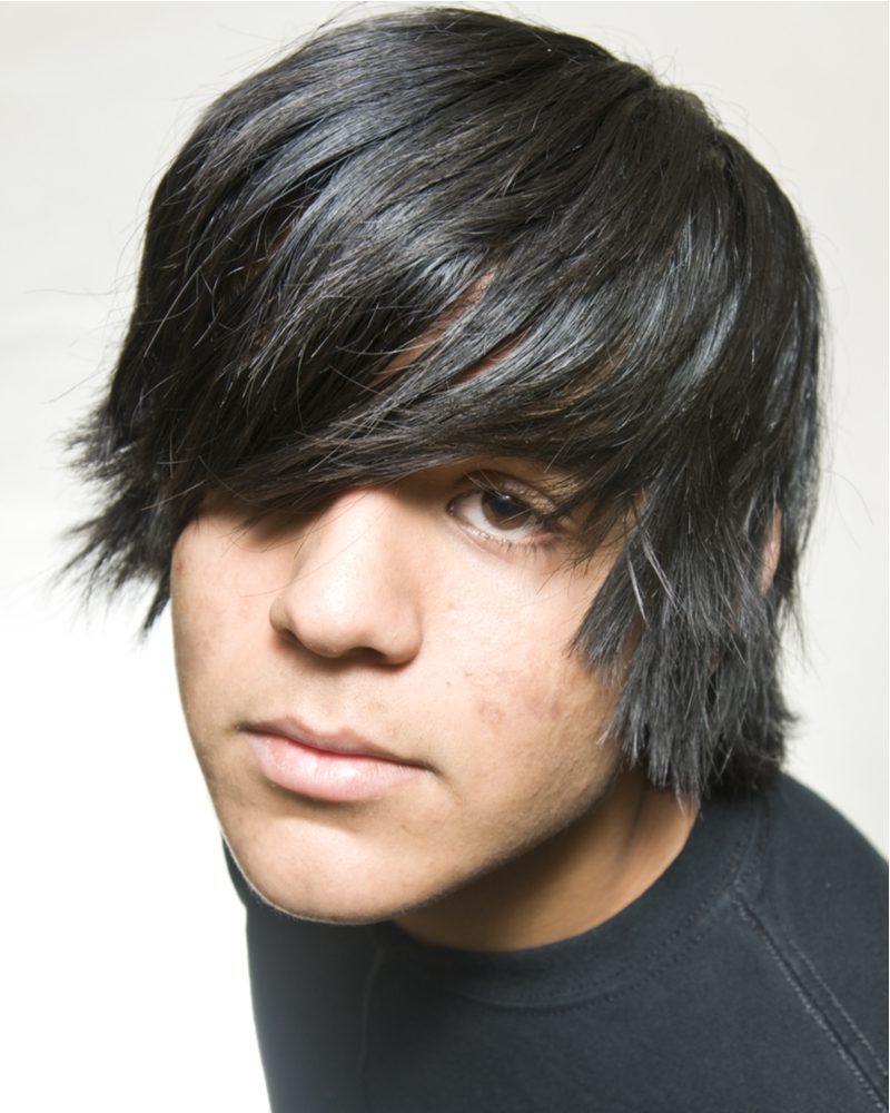 Emo hairstyle of side-swept bangs on a guy in a black shirt