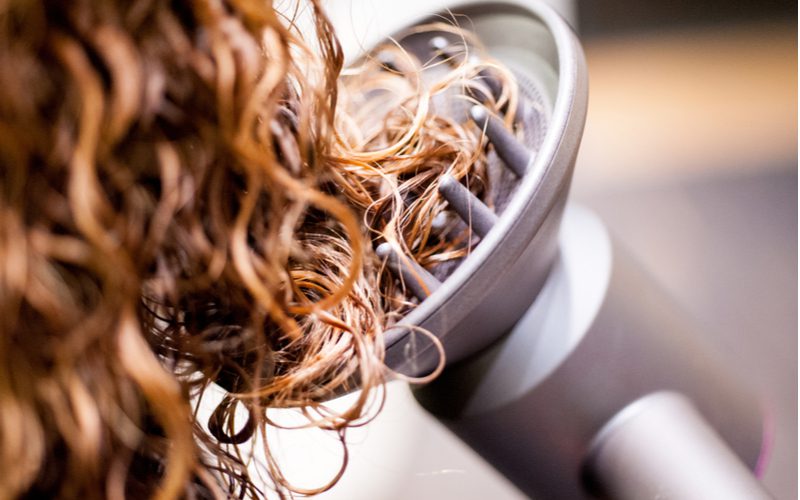 Image of a woman getting a perm with a Dyson hair dryer diffuser