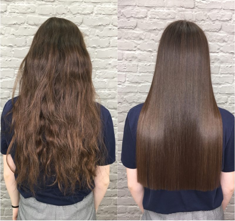 Để minh họa cho cách làm thẳng tóc mà không cần nhiệt, một cô gái quay mặt ra khỏi máy ảnh với mái tóc thật dài đứng trước bức tường gạch