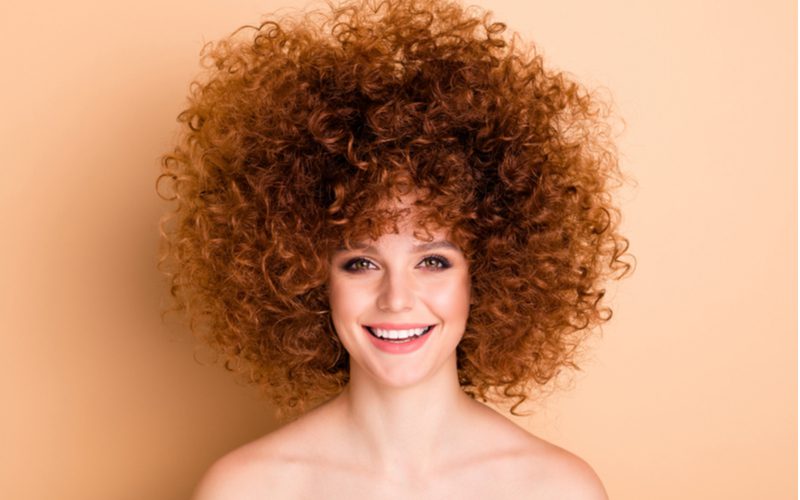 Gal with crazy curly hair just read our guide on how to care for permed hair and her hair looks natural and fresh and bouncy
