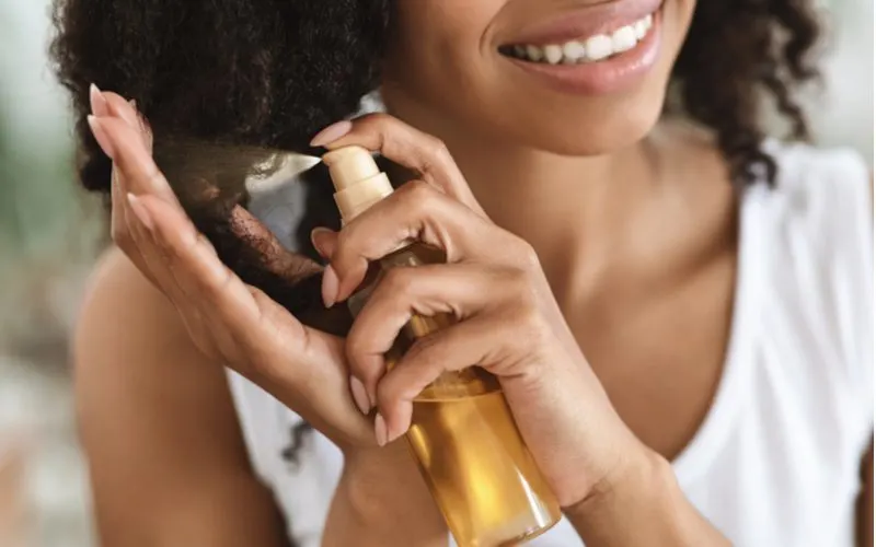 Woman hydrating her hair with serum to get rid of frizzy hair