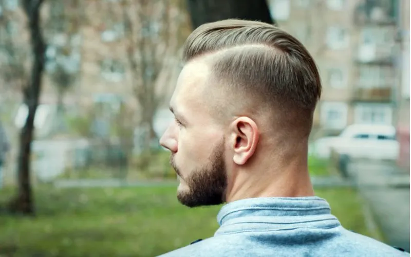 Gent with a sporty undercut fade looks to his right and wears a grey collared sweatshirt