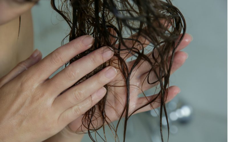 For a piece on how to dry curly hair, and image of wet hair being rung out in a bathtub