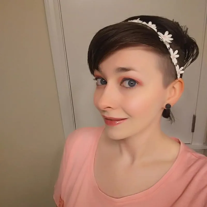 Woman with a mohawk for females with a combed-over top wearing a floral headband