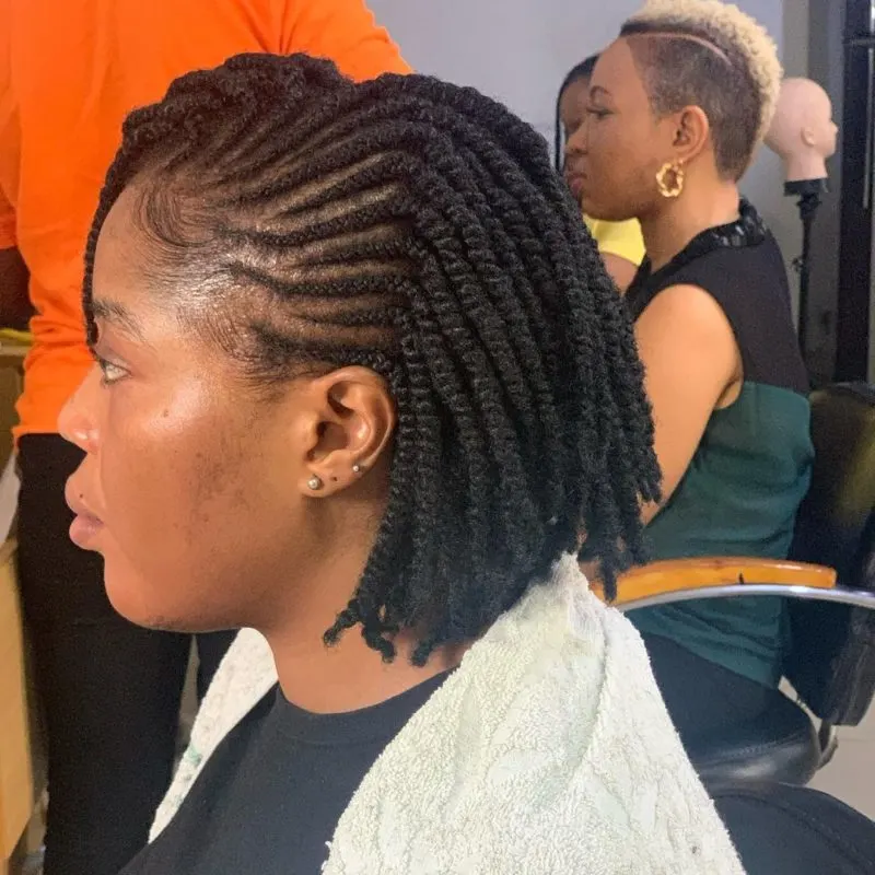 Girl with kinky side-parted twists in a blazer in a braiding shop