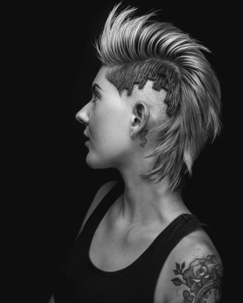 Female mohawk on a woman with a strange fade cut into a unique pattern in a black and white image