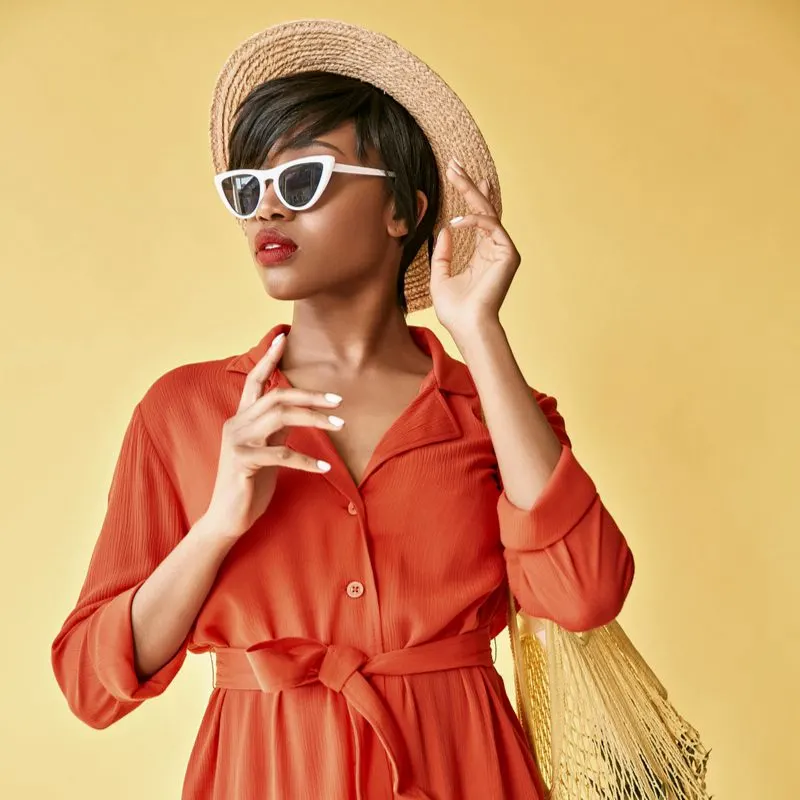 Choppy Textured Black Bob Haircut on an Afro-American woman in a touristy hat and a red dress