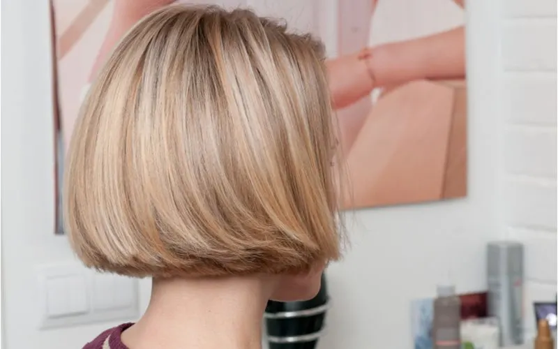 Bob haircut with layered ends on a woman in a studio looking ahead so we can't see her face