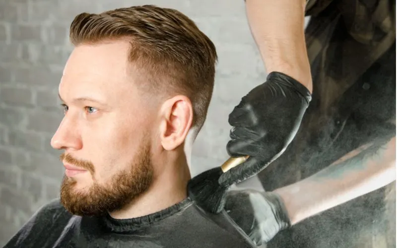 Example of a low fade haircut on a guy with piercing blue eyes and a well-manicured beard