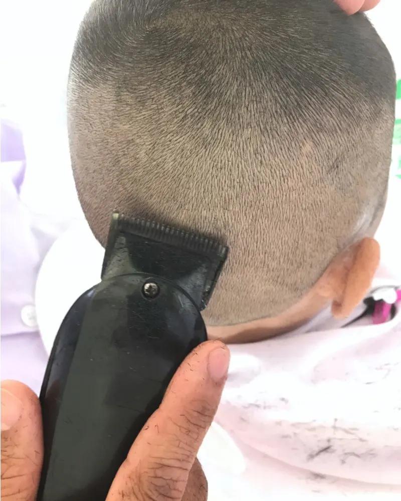 Kid getting a buzzcut shown from the barber's perspective