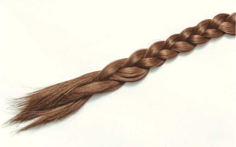 For a piece on braids for men, a standard three-strand braid sits on an off-white background
