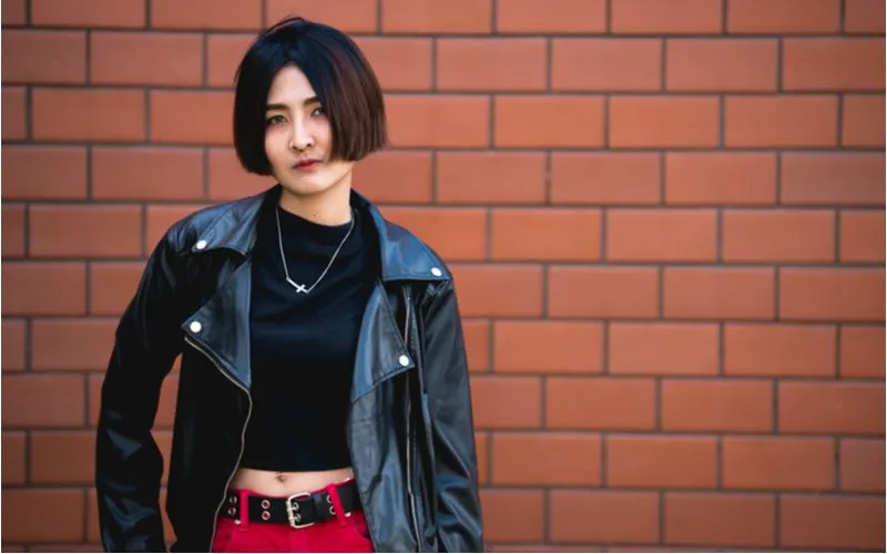 Blunt Bob punk hairstyle worn by a roman in a black leather jacket and red pants