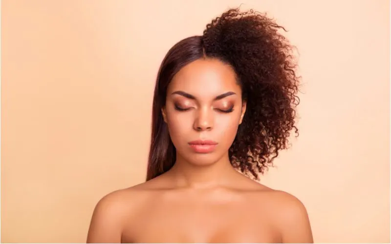 For a piece on the best straightening product for black hair, a woman sits in a side-by-side image showing what happens after and before she used the product