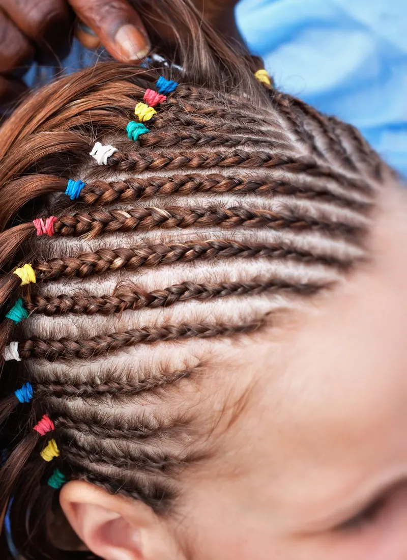 White woman with tribal braids and multiple colored bands with tight cornrows