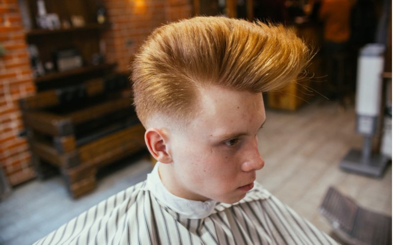 Psychobilly Wedge pompadour haircut on a guy with red hair in a striped cape