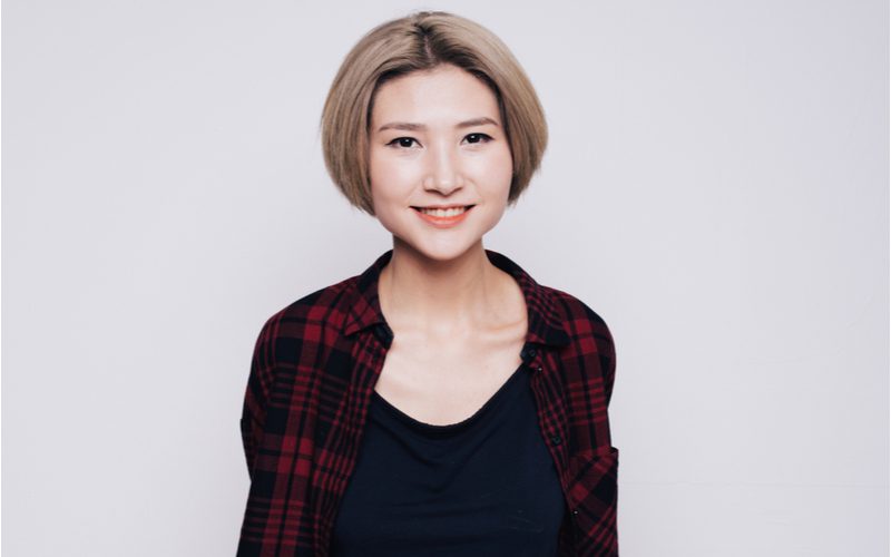 Basic tapered short bob haircut on an Asian woman in a red and black flannel shirt