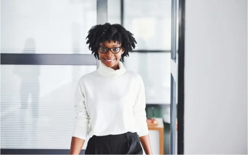 Accessorized Locs being worn by a business woman in a white blouse and black skirt in a modern office