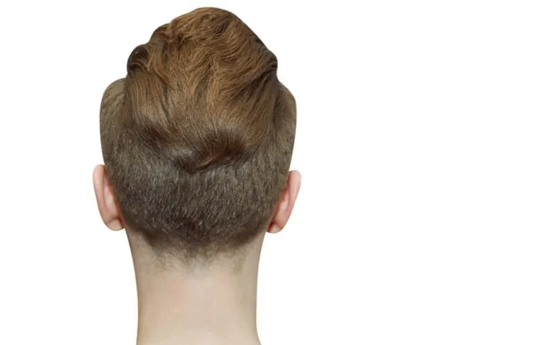 Pompadour Faux Hawk on a guy facing a white wall and looking away from the reader