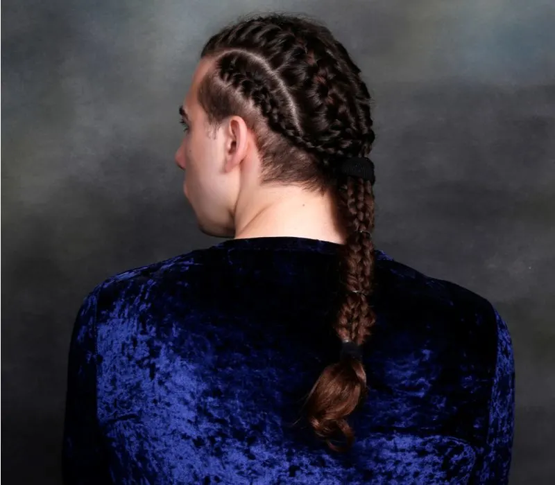 Guy with a viking braid ponytail in a blue suede sparkly shirt