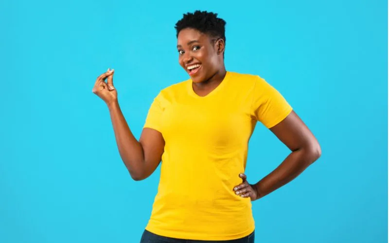 Kinky Drop Fade hairstyle for black woman on a gal in a yellow shirt in a blue room