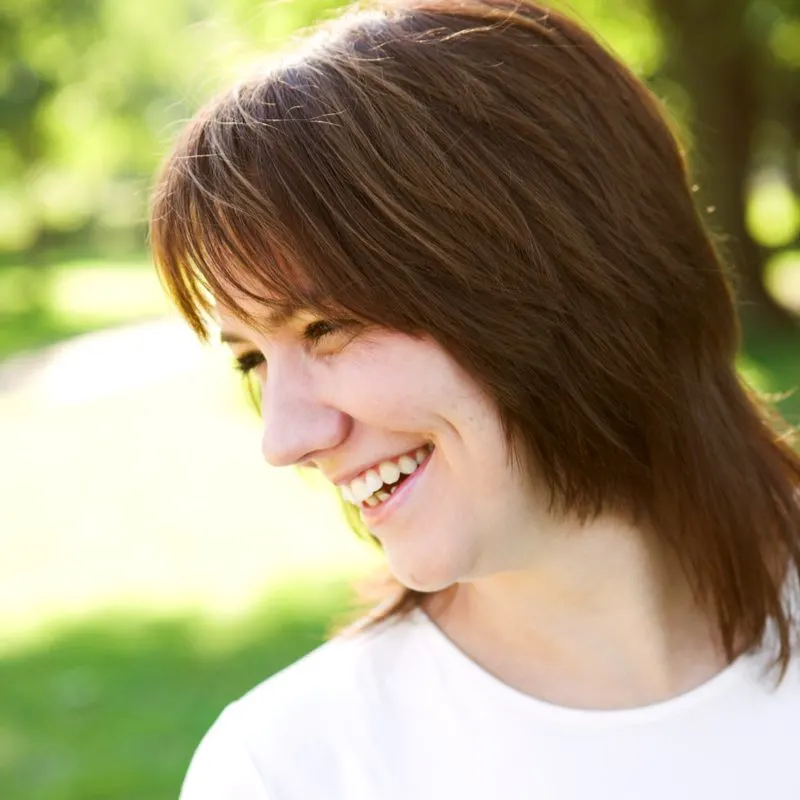 Collarbone-grazing shag haircut on a smiling woman standing outside