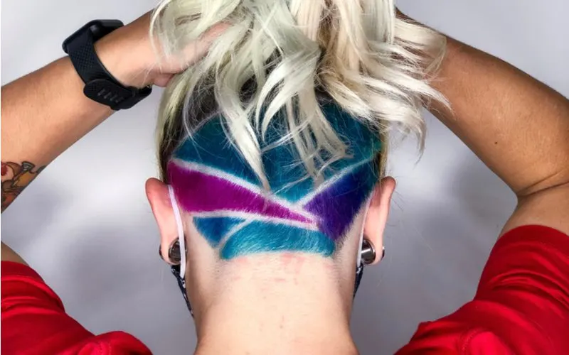 Girl with an undercut bob that's also faded in the back with hard shave lines dyed in multiple colors in the various parts