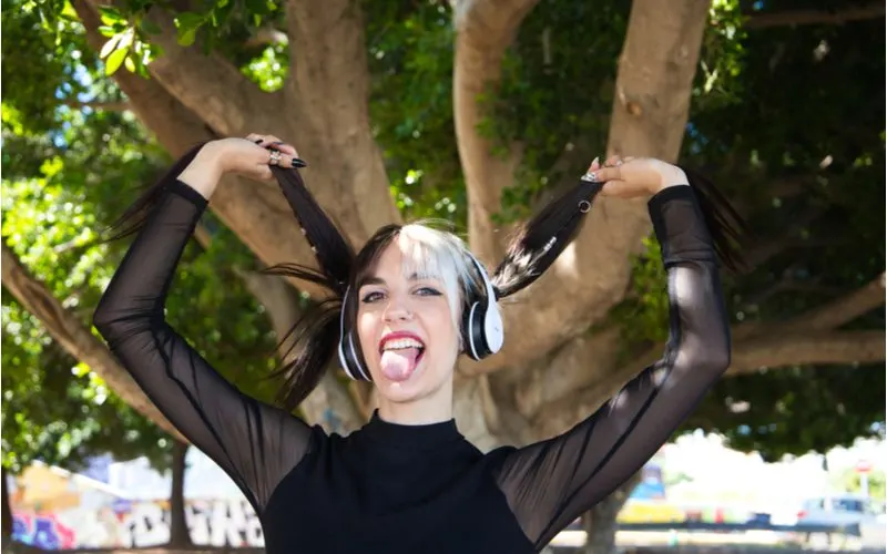 Two-Tone Pigtails, a punk hairstyle, on a woman in a sheer black shirt and white headphones
