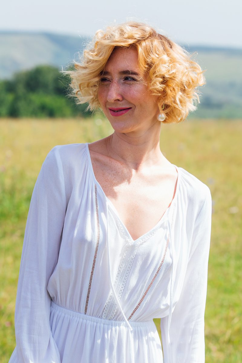 Chin-Length and Curly Stacked Bob Worn by a Woman in a Field