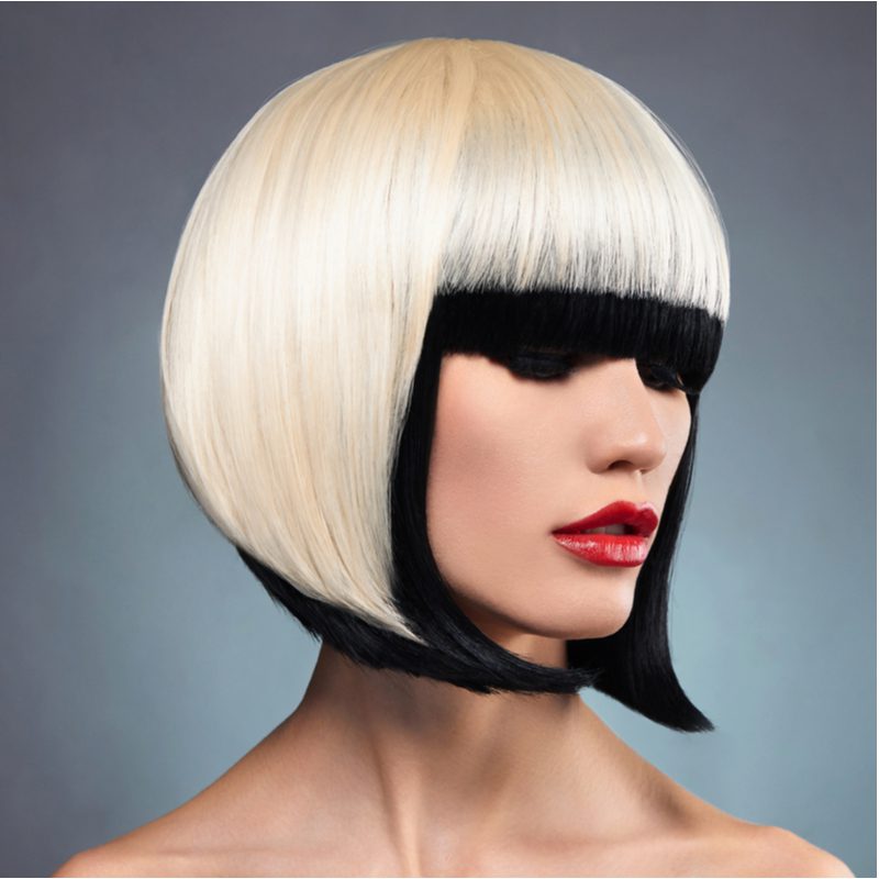 Woman with two toned hair in bright blonde and black trim with red lip in a side profile image