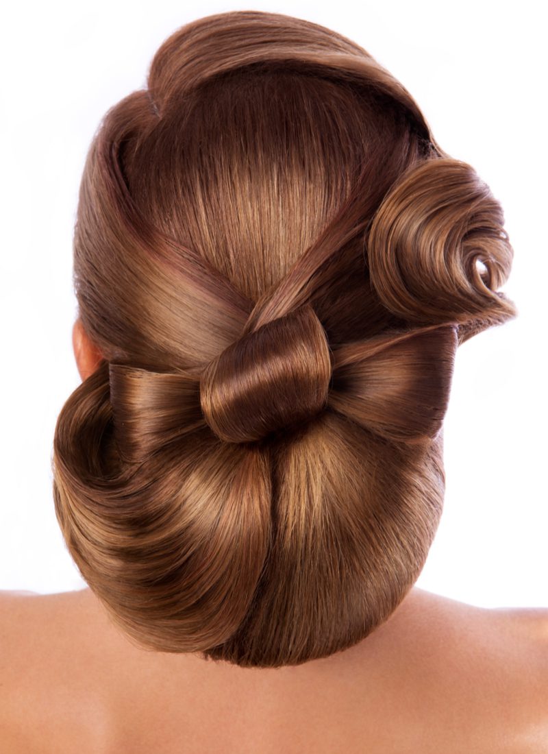 For a featured mother of the groom hairstyle, a woman tied her hair into a bow and posed in a studio for this image