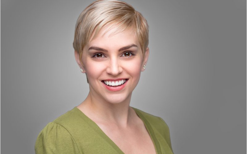 Woman with a pixie cut, an easy everyday hairstyle, in a green shirt smiling