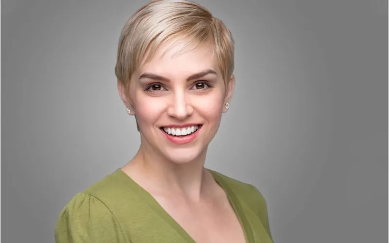 Woman with a pixie cut, an easy everyday hairstyle, in a green shirt smiling