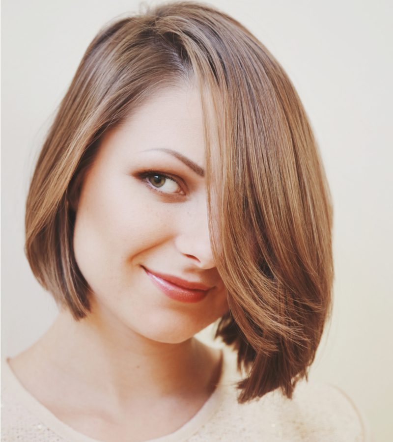 Inverted and Side-Parted Bob on a woman in a white sequin sweater